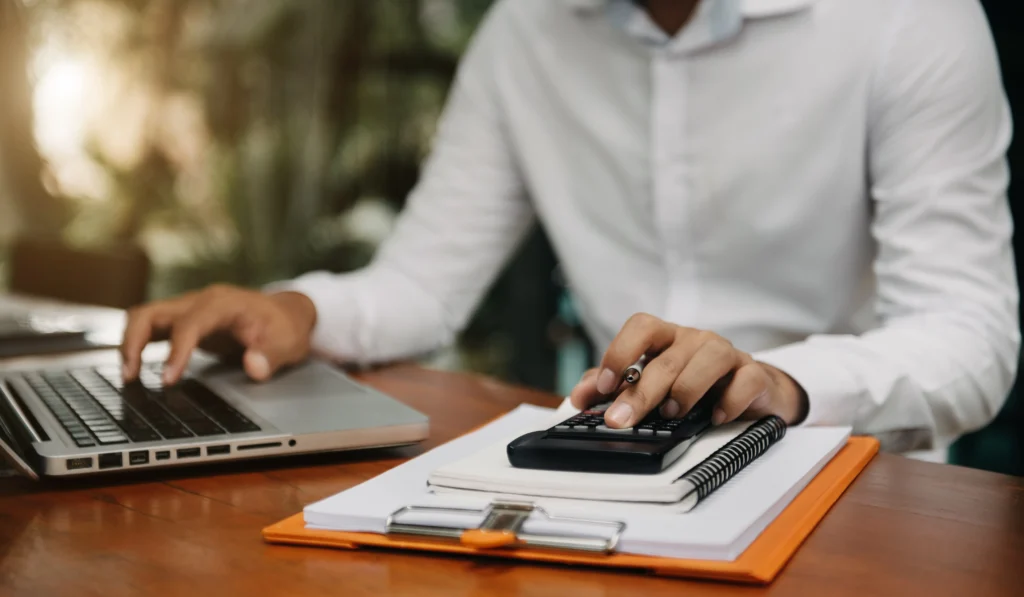 male businessman working desk with using calculator calculate numberslaptop finance accounting concept