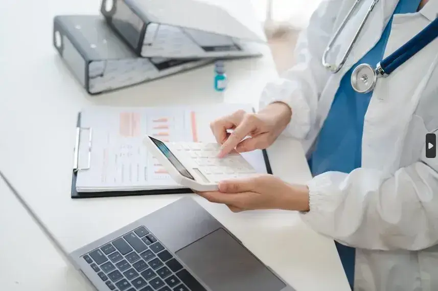 zoomed in view of a doctor's hands using calculator