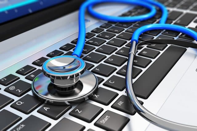 A stethoscope resting on a laptop keyboard, symbolizing the integration of technology in healthcare