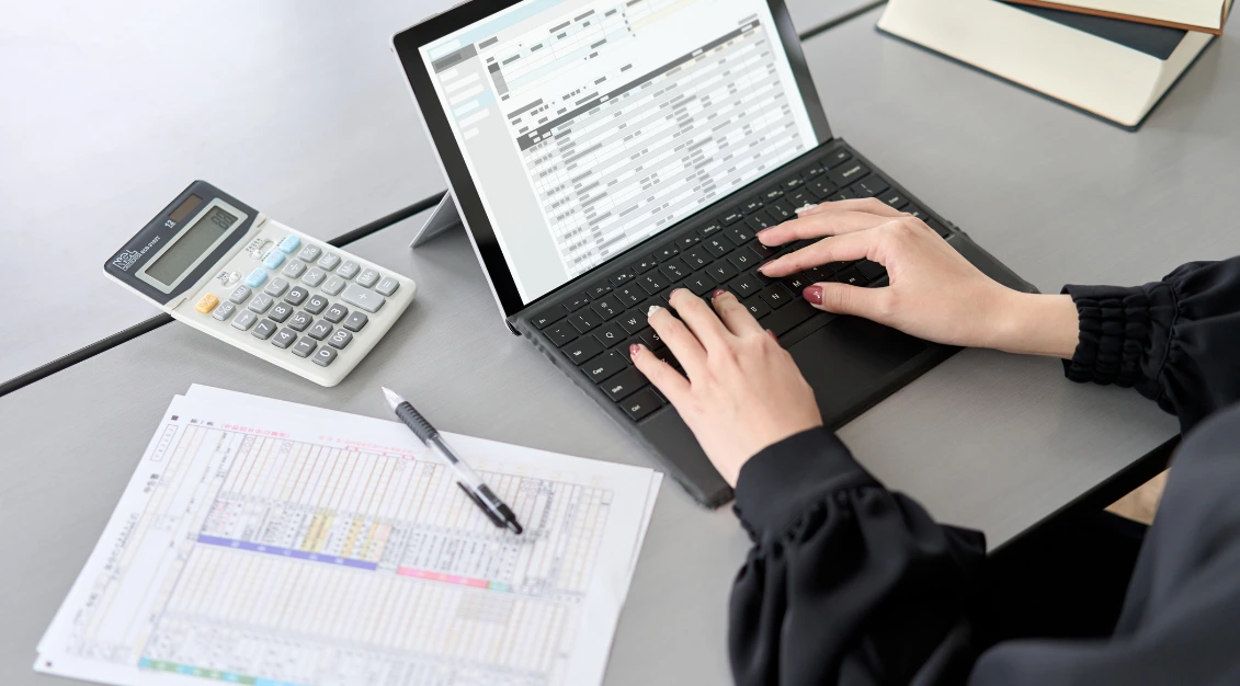 close up of female hands filling patient information on a laptop