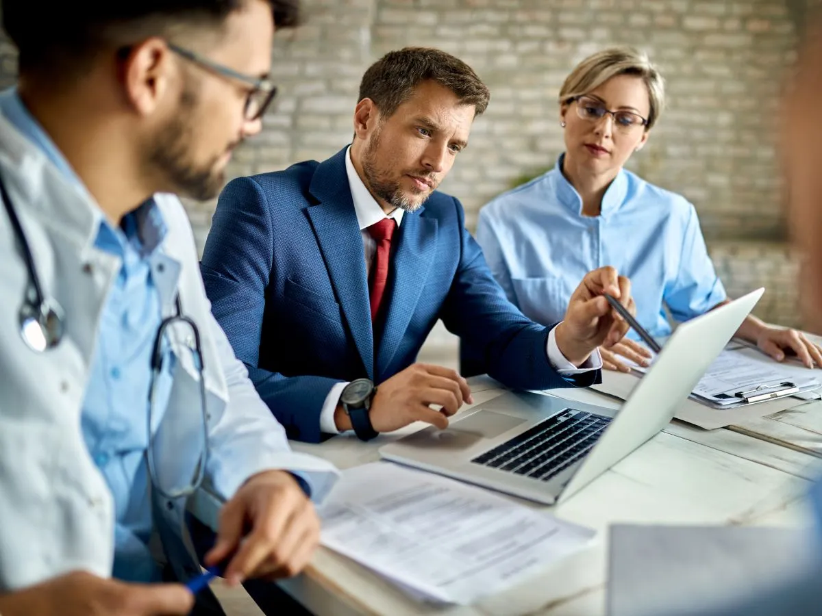 2 medical billing consultants discussing something with a doctor