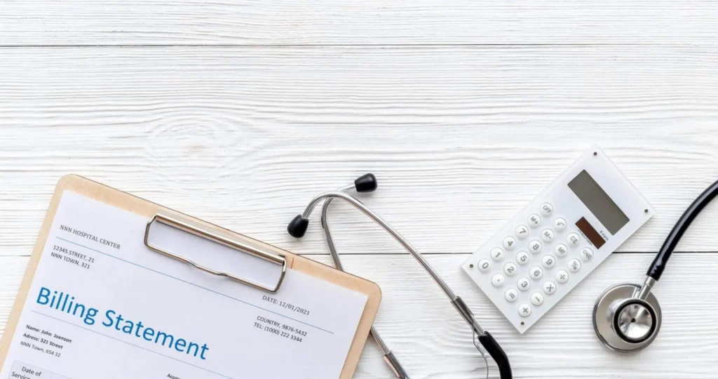 A medical billing statement, stethoscope, and calculator, representing healthcare billing and financial management.