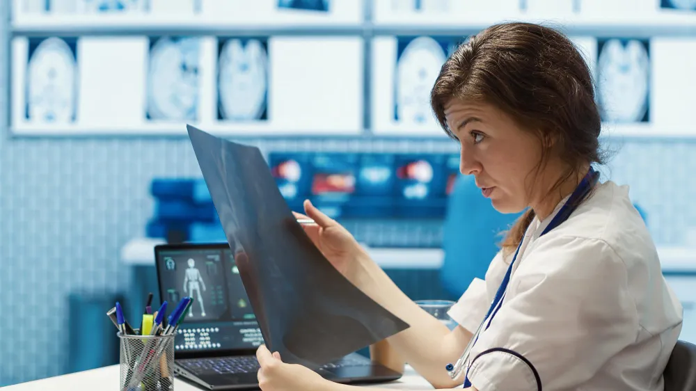 a doctor confusingly reading an xray report_11zon