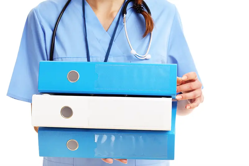 close up of a healthcare provider holding documentation files