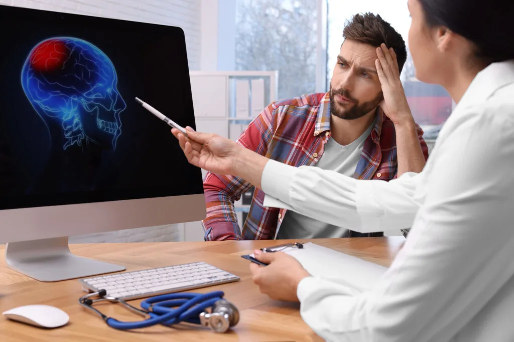a neurologist discussing brain xray with a boy