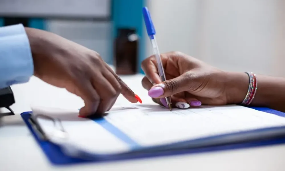 Hands pointing and writing on a document.
